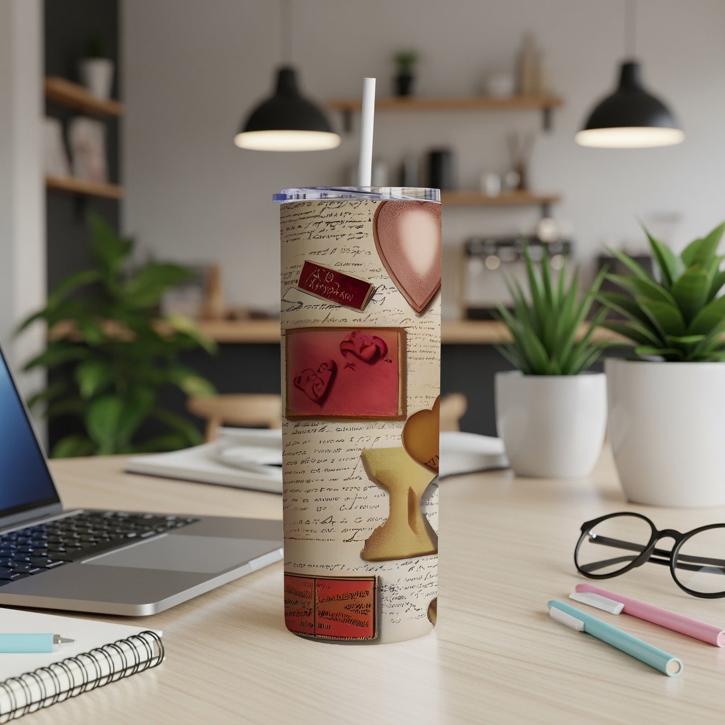 Tumbler with heart designs and handwritten script on a desk.