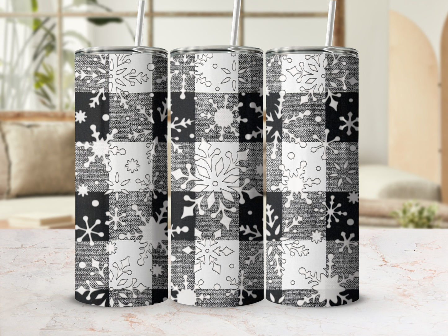 Three buffalo plaid tumblers with snowflake designs and straws.