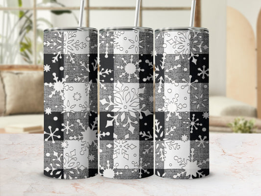 Three buffalo plaid tumblers with snowflake designs and straws.