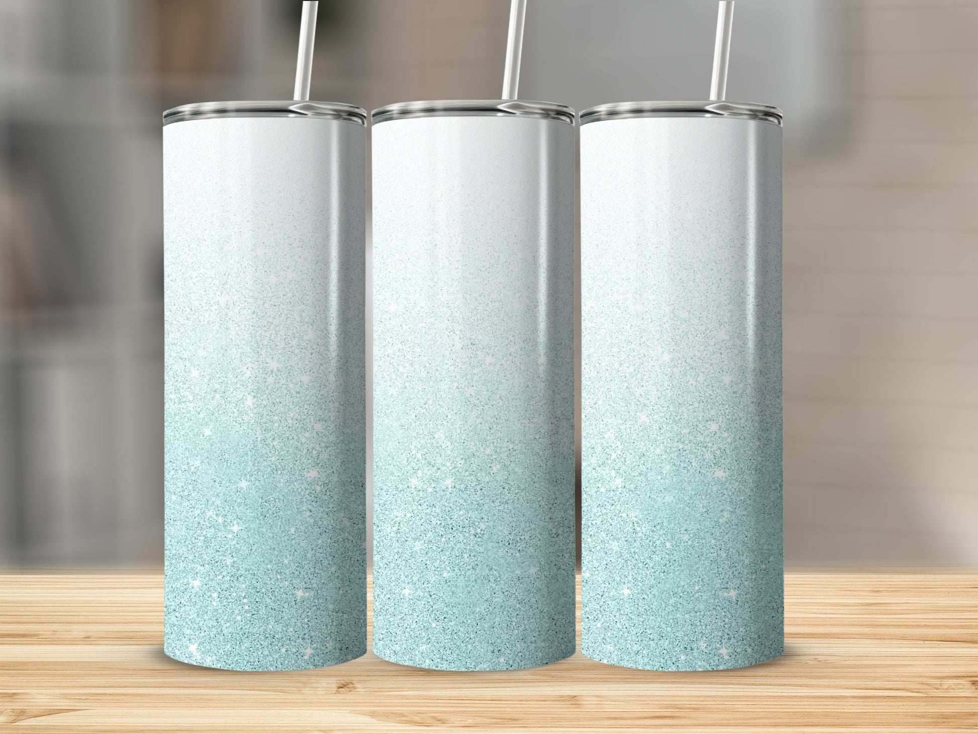 Three tall, frosted tumblers with a white to light blue glitter ombre design.