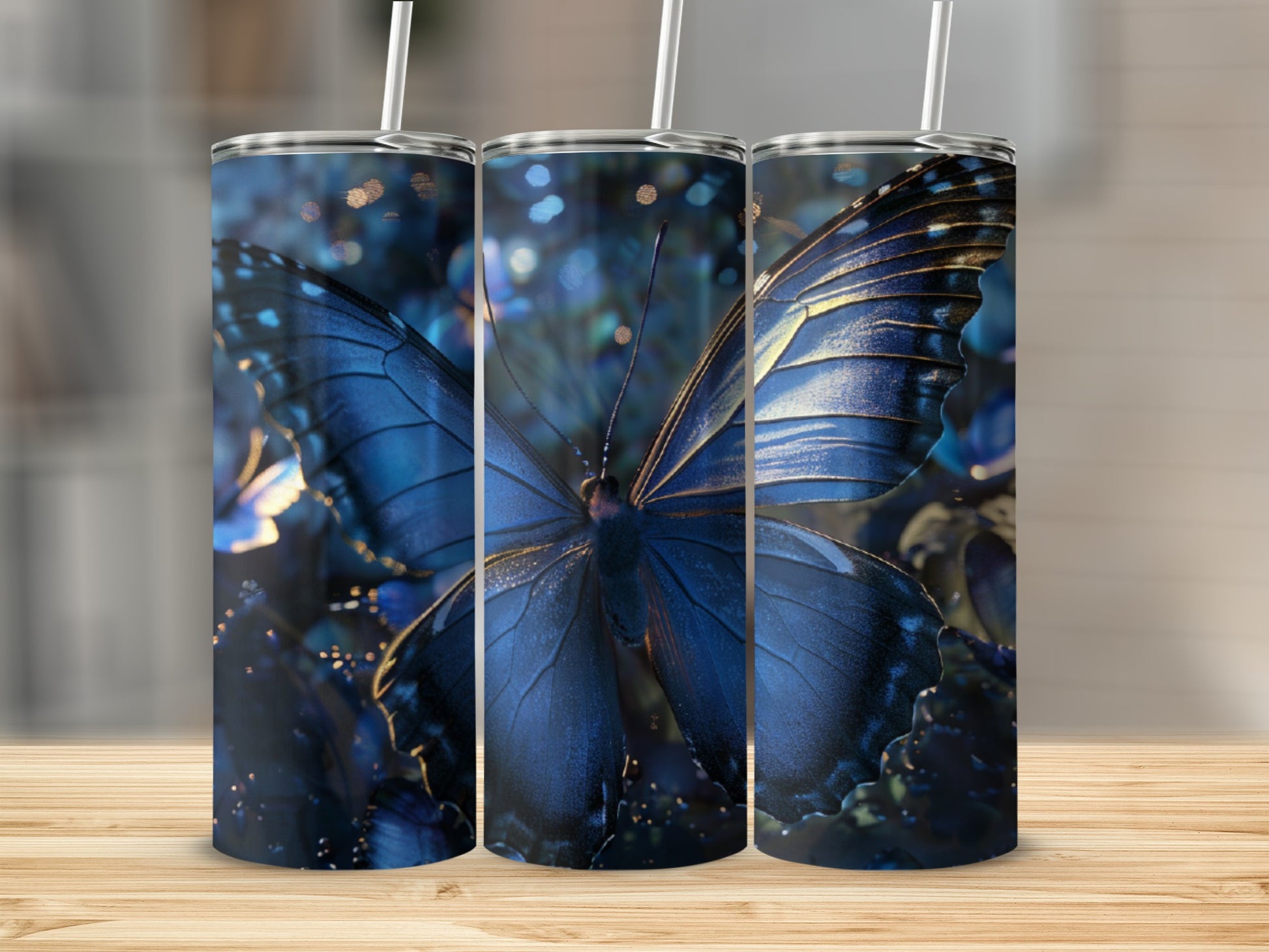 Three tumblers with a close-up blue butterfly design on a wooden surface.