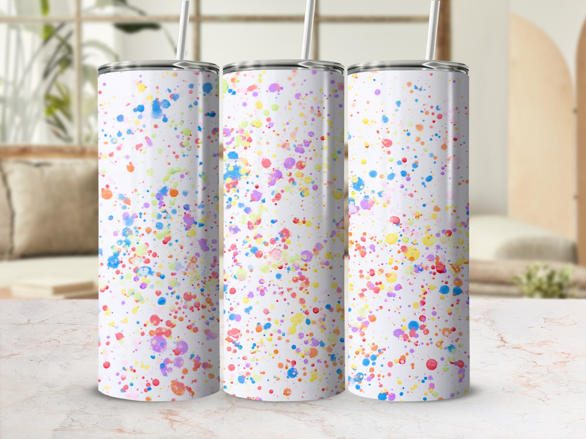 Three white tumblers with colorful paint splatter design.