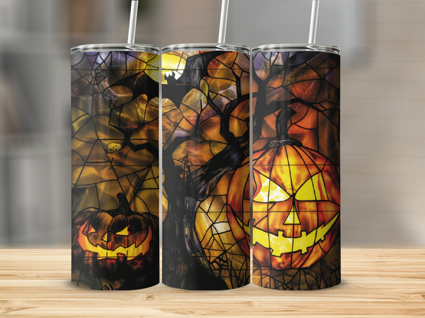 Three Halloween tumblers with glowing jack-o'-lanterns and spooky trees.