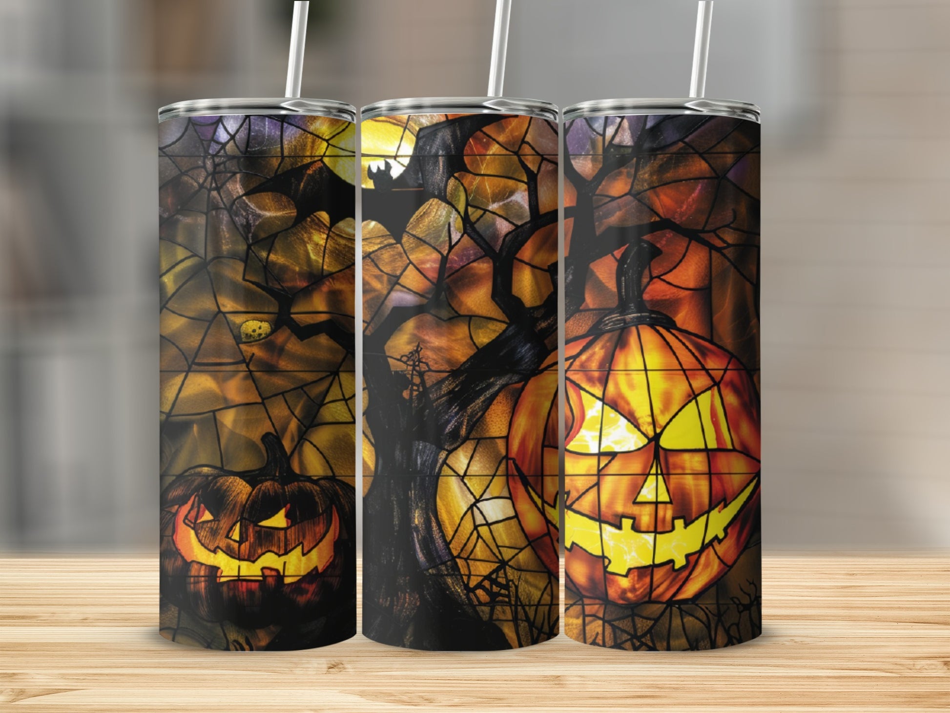 Three Halloween tumblers with glowing jack-o'-lanterns and spooky trees.