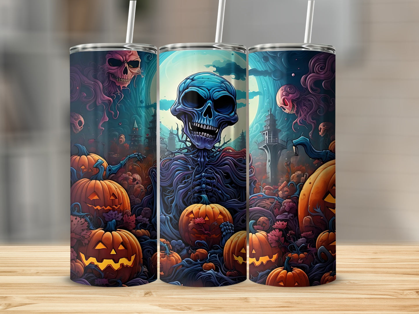 Three tumblers with Halloween skeleton and jack-o'-lantern designs on a wooden surface.