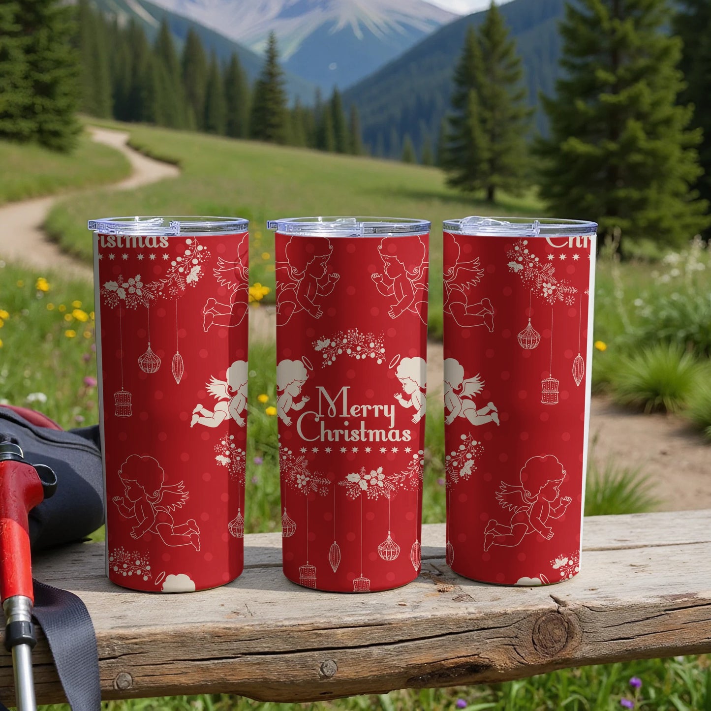 Three red tumblers with angels and "Merry Christmas" text on a wooden surface.