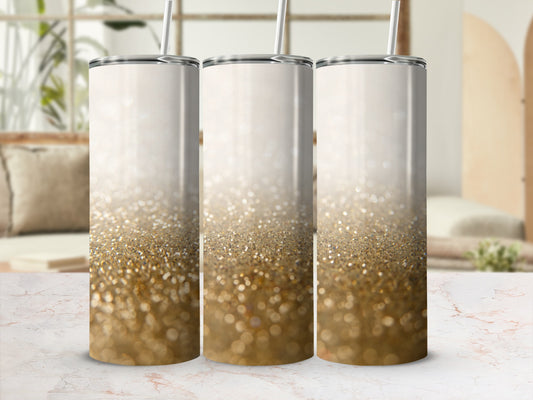 Three glitter tumblers with straws on a marble surface.