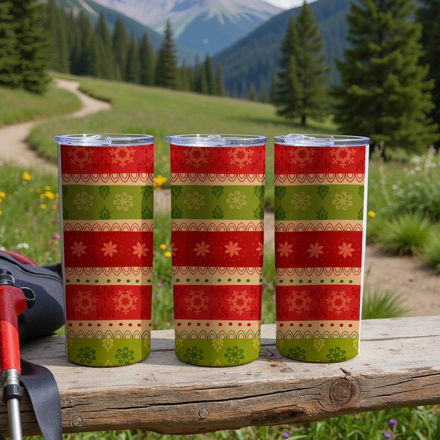 Three striped tumblers with festive patterns on a wooden surface.