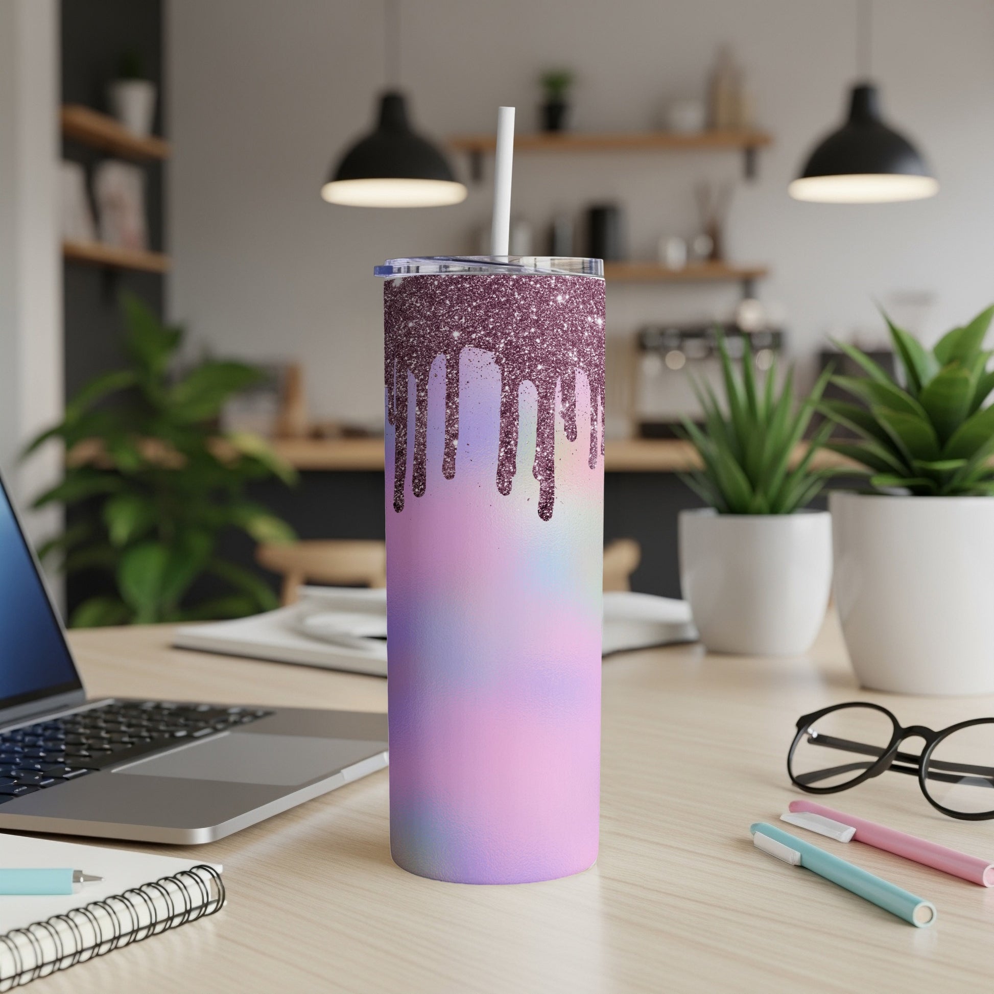 Glittery drip tumbler with pastel watercolor design and straw on a desk.