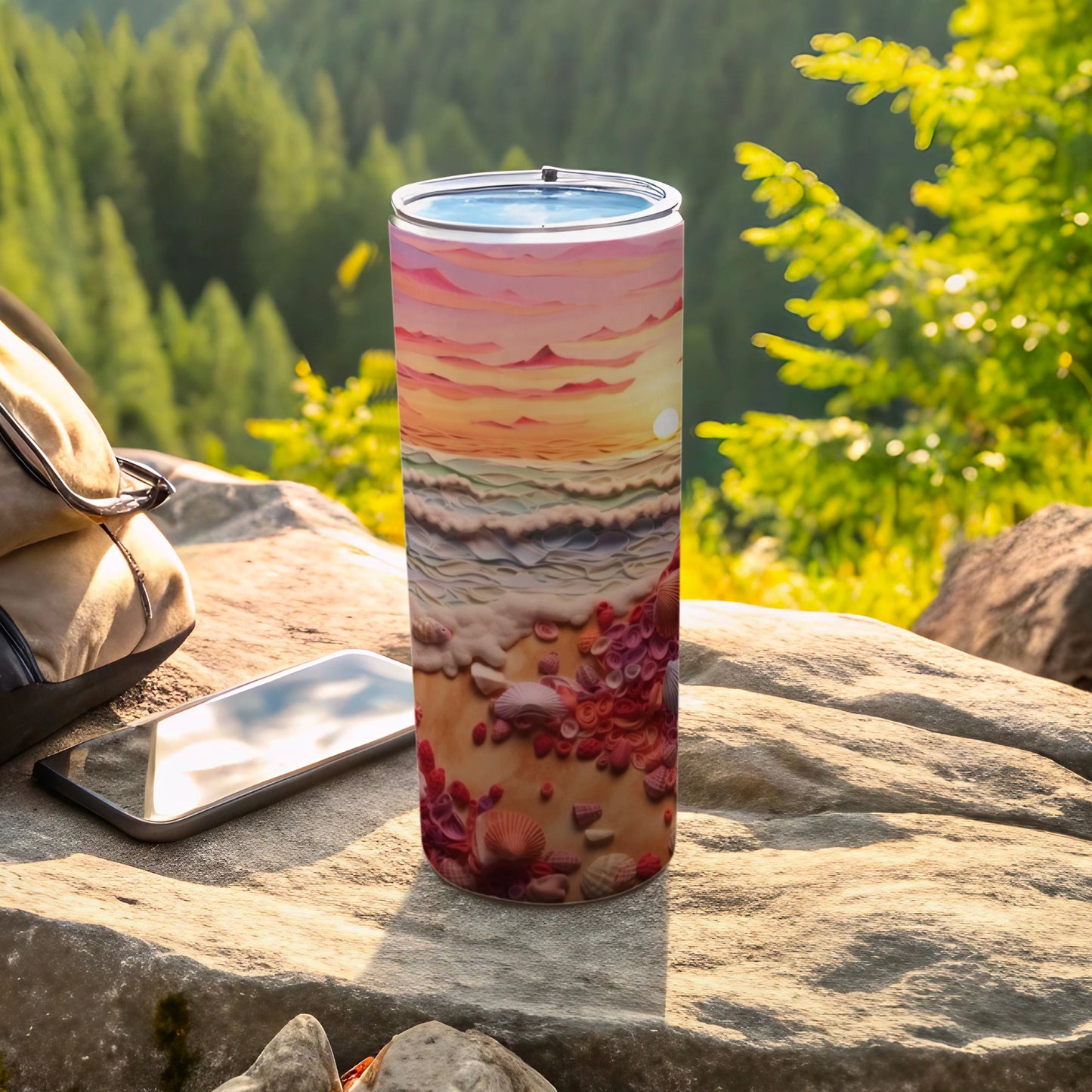 Tumbler with sunset ocean beach scene, phone, and backpack.