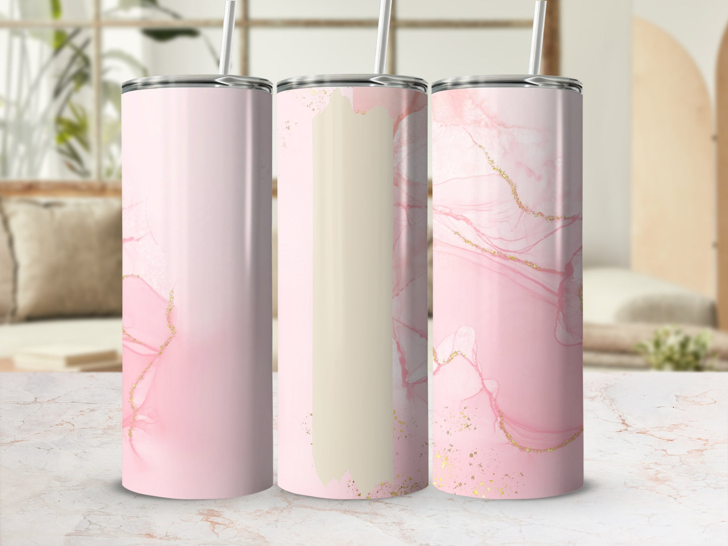 Three pink marble tumblers with gold accents and straws.