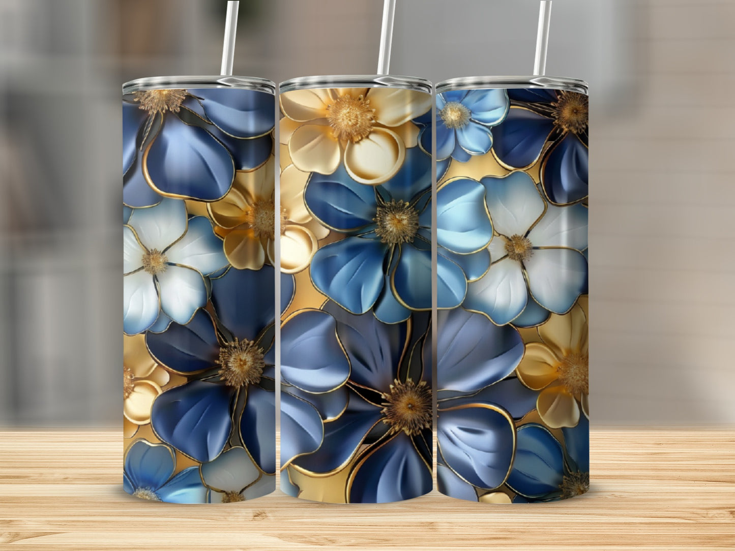 Three tumblers with blue, gold, and white floral patterns stand side-by-side.
