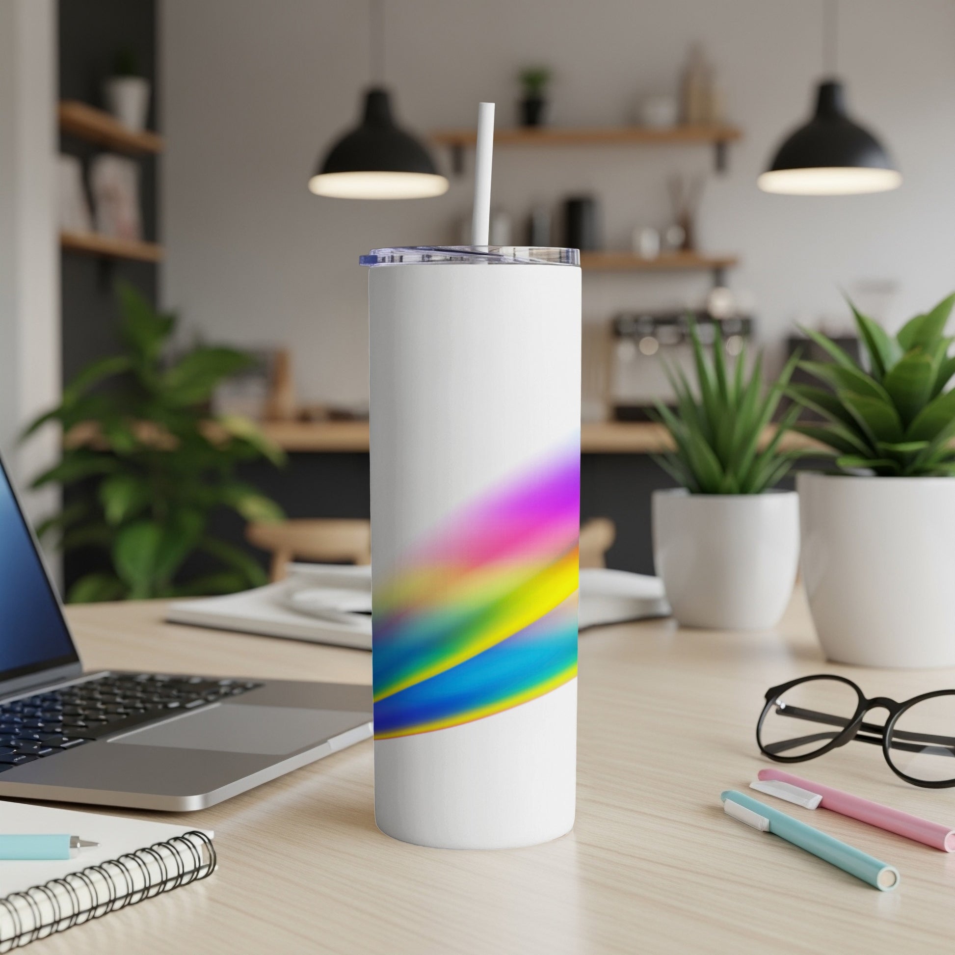 White tumbler with colorful abstract brush strokes and a straw.
