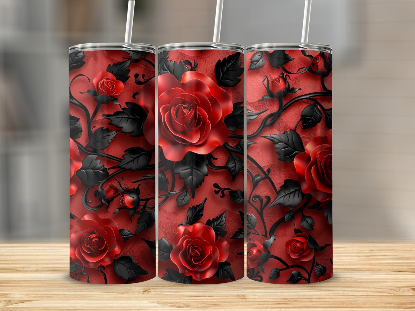 Three tumblers with a red rose and black vine pattern on a wooden surface.