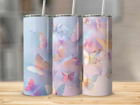 Three tumblers with pastel butterfly designs stand on a wooden surface.