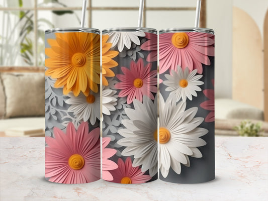 Three tumblers with daisy floral designs in pink, white, and yellow on gray.