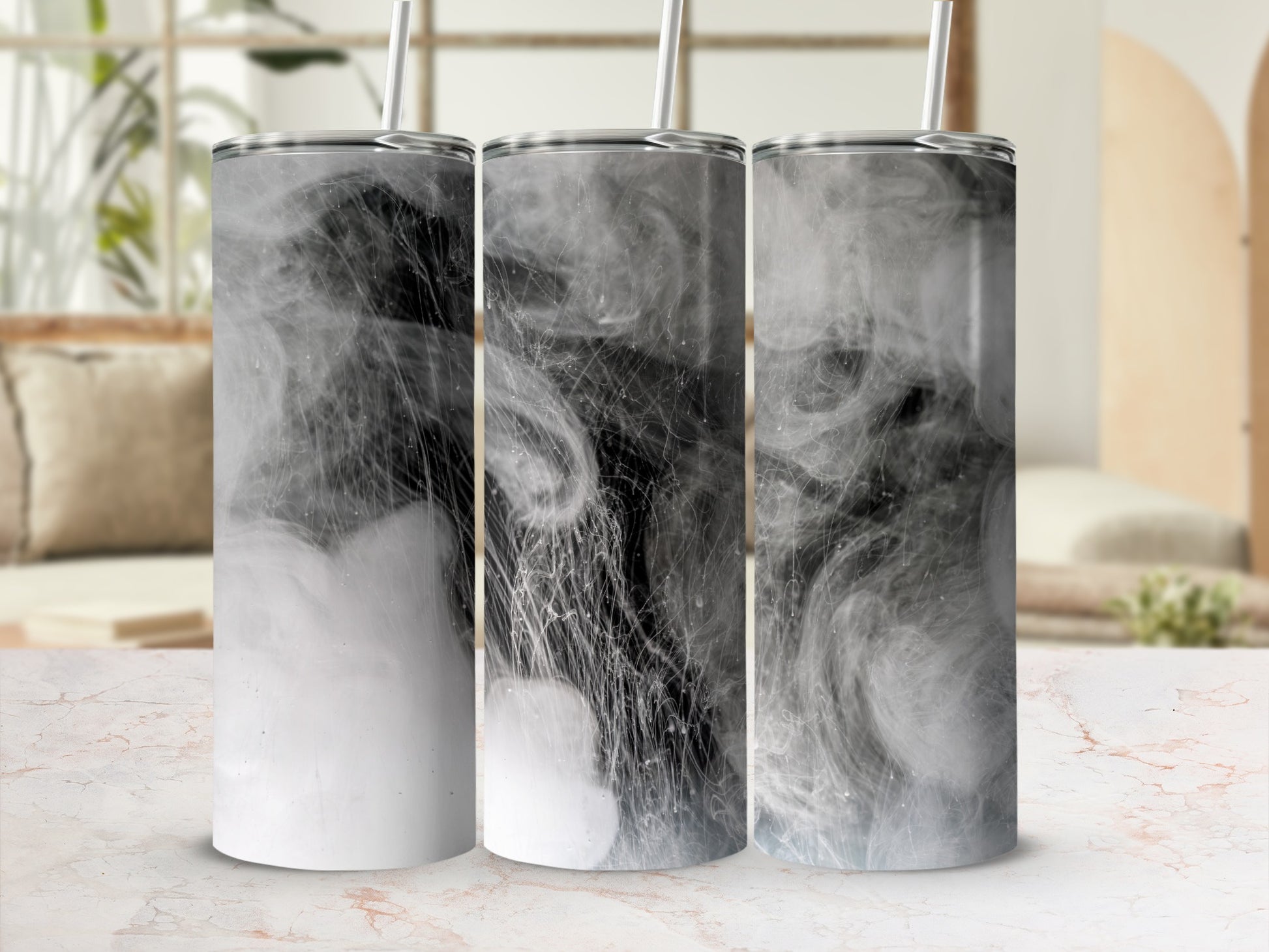 Three tumblers with smoky, abstract designs on a countertop.