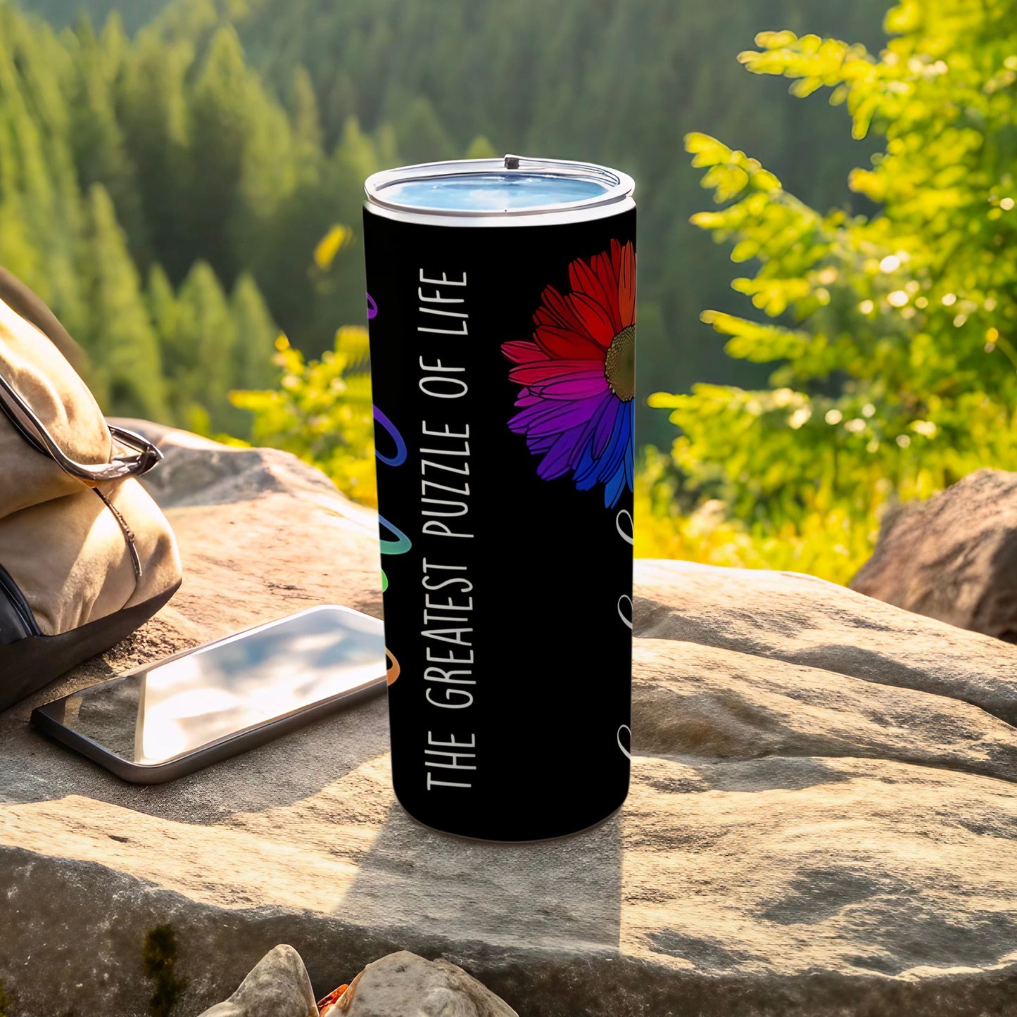 Black tumbler with a colorful flower and "The Greatest Puzzle of Life" text.