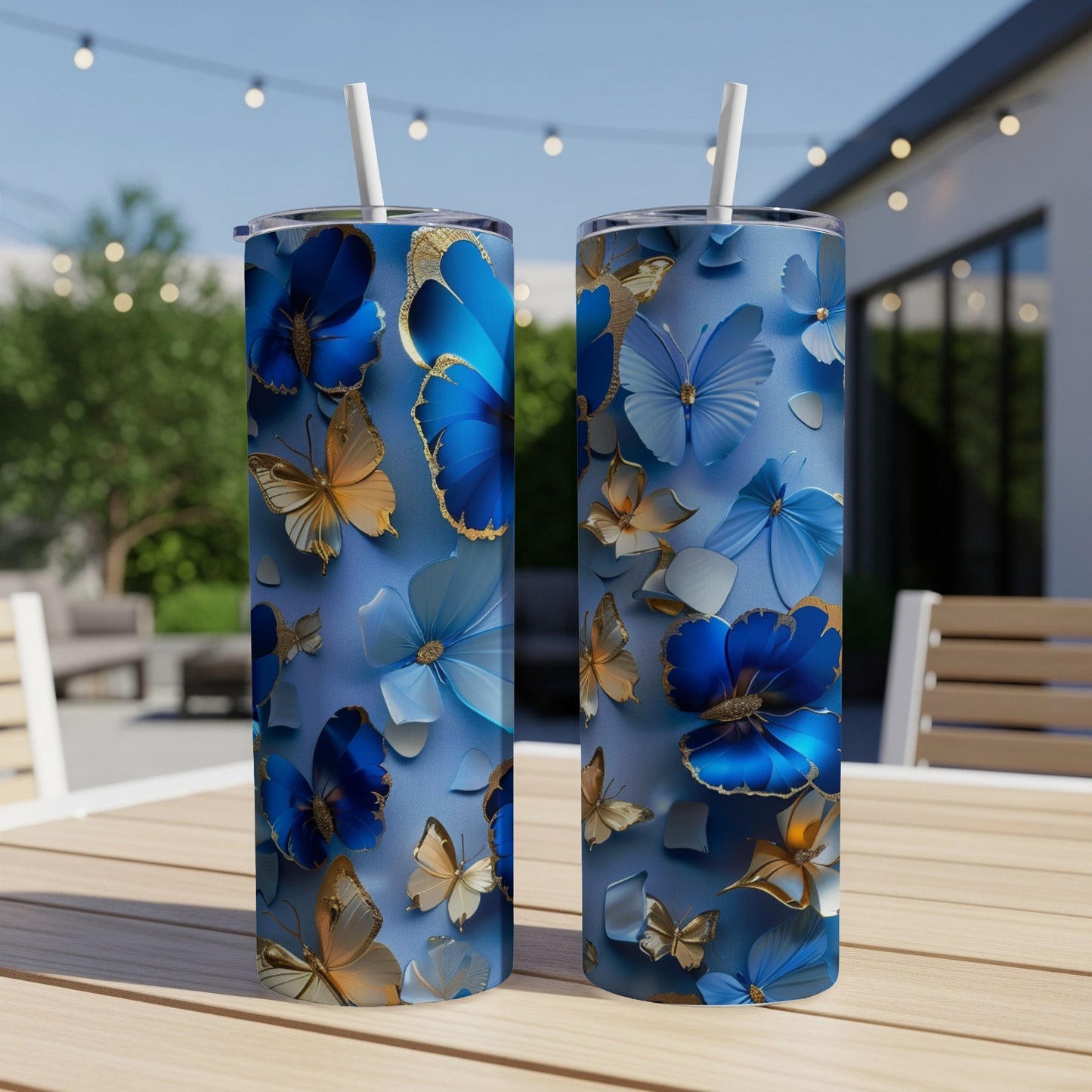 Two blue tumblers with golden and blue butterfly and flower designs.
