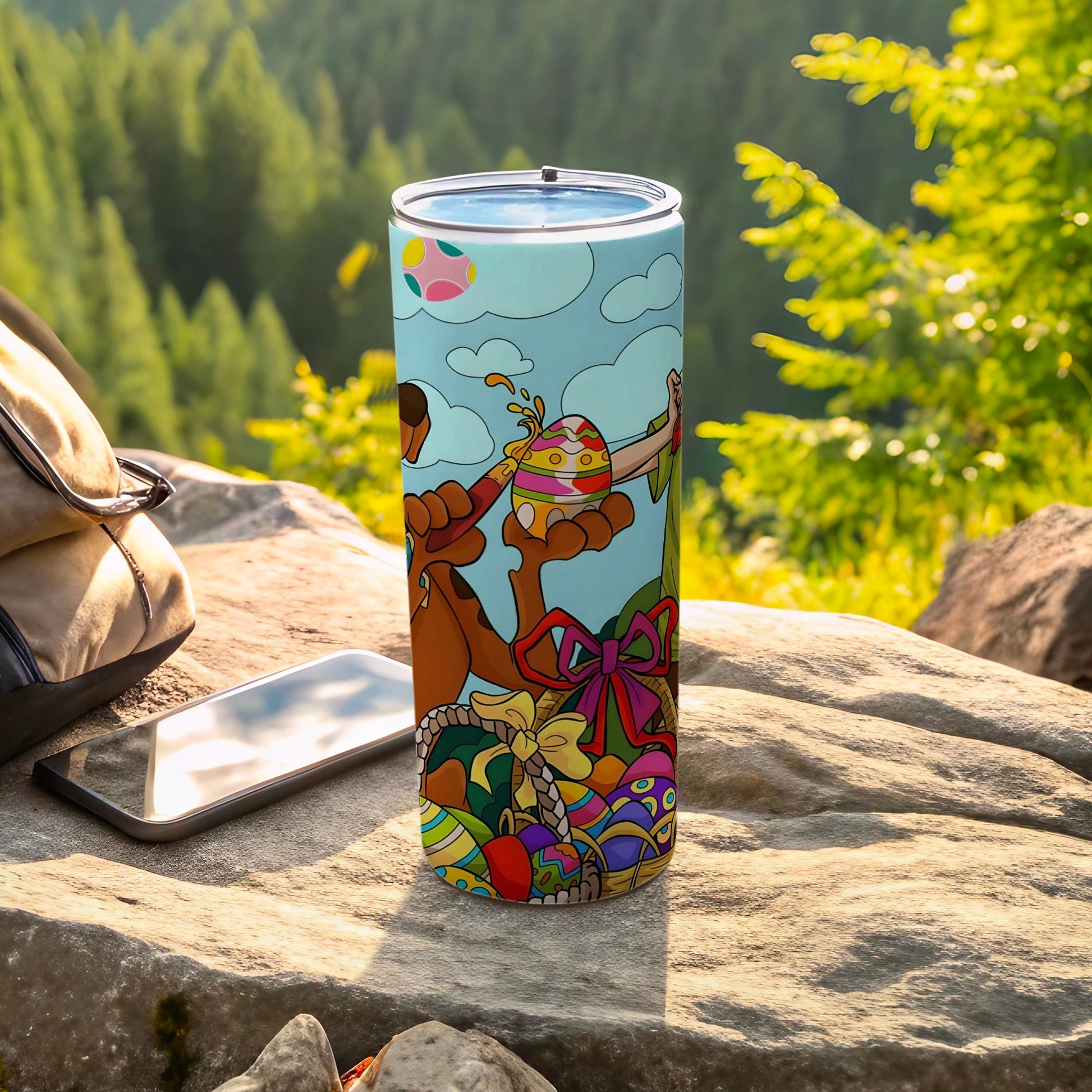 Tumbler with colorful Easter eggs, a rabbit, and a basket on a natural outdoor background.