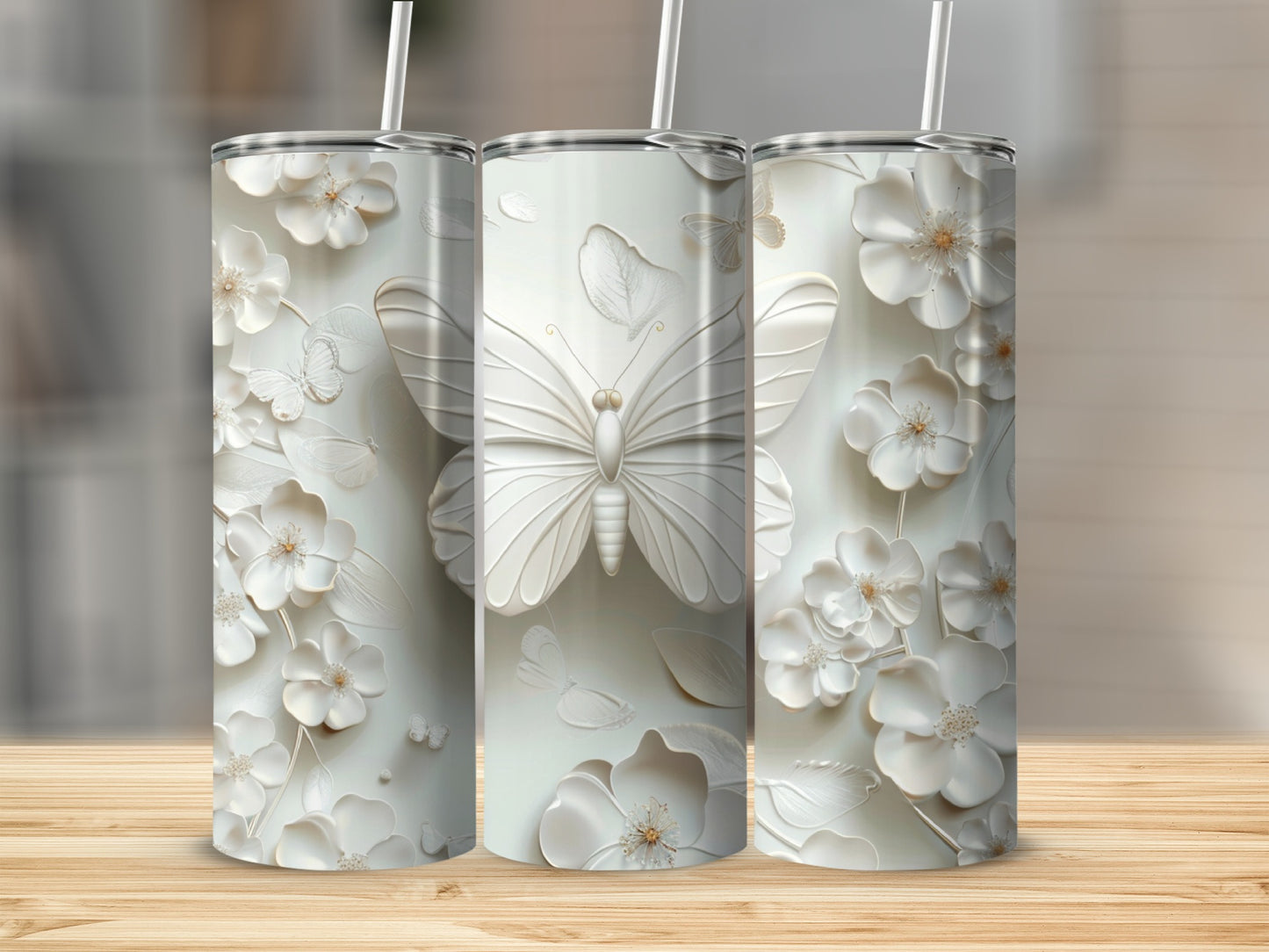 Three white tumblers with embossed floral and butterfly designs on a wooden surface.