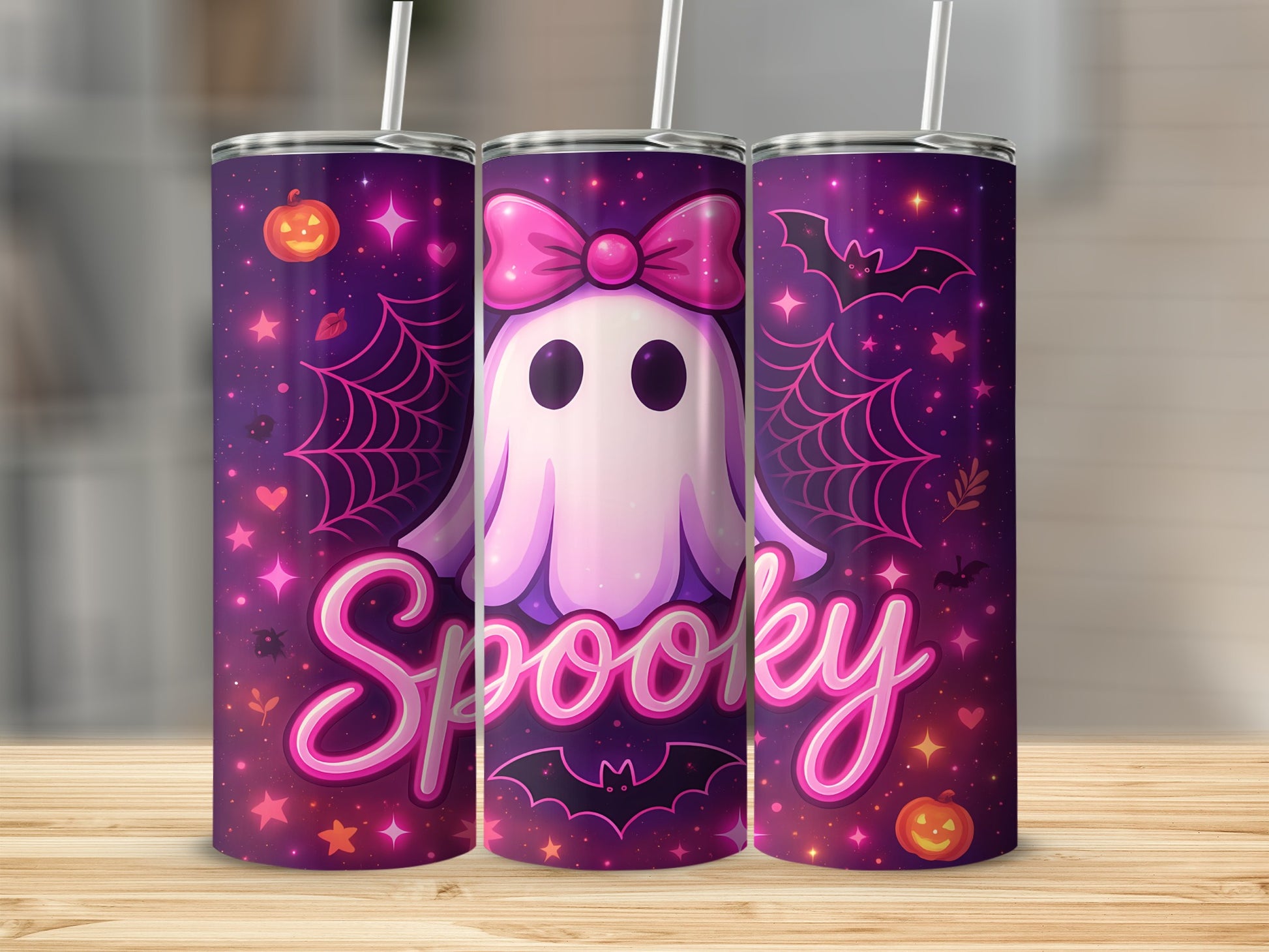 Three tumblers with a pink ghost, bow, bats, pumpkins, and "Spooky" text on a purple background.