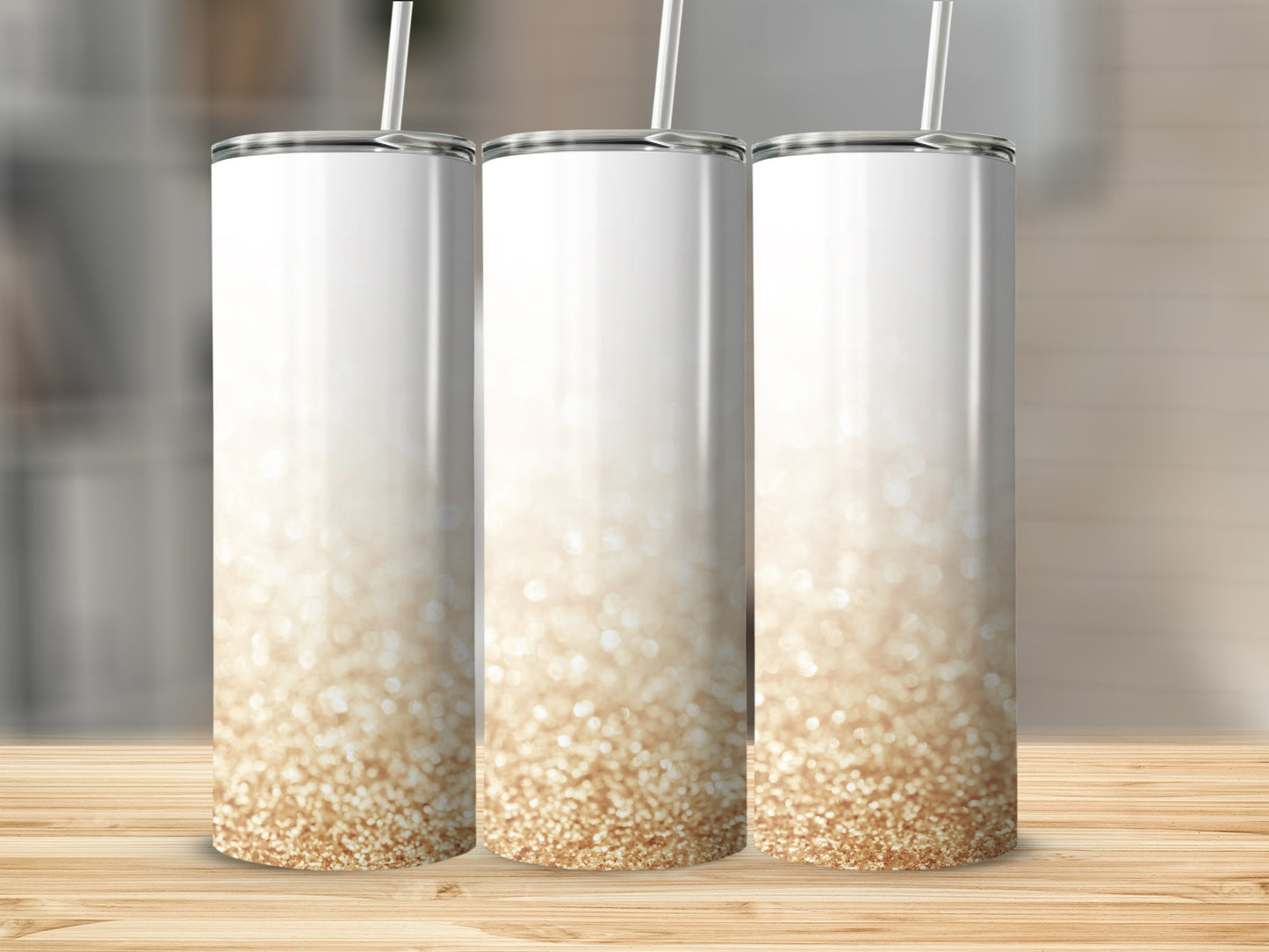 Three white tumblers with gold glitter gradient on a wooden surface.