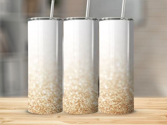 Three white tumblers with gold glitter gradient on a wooden surface.