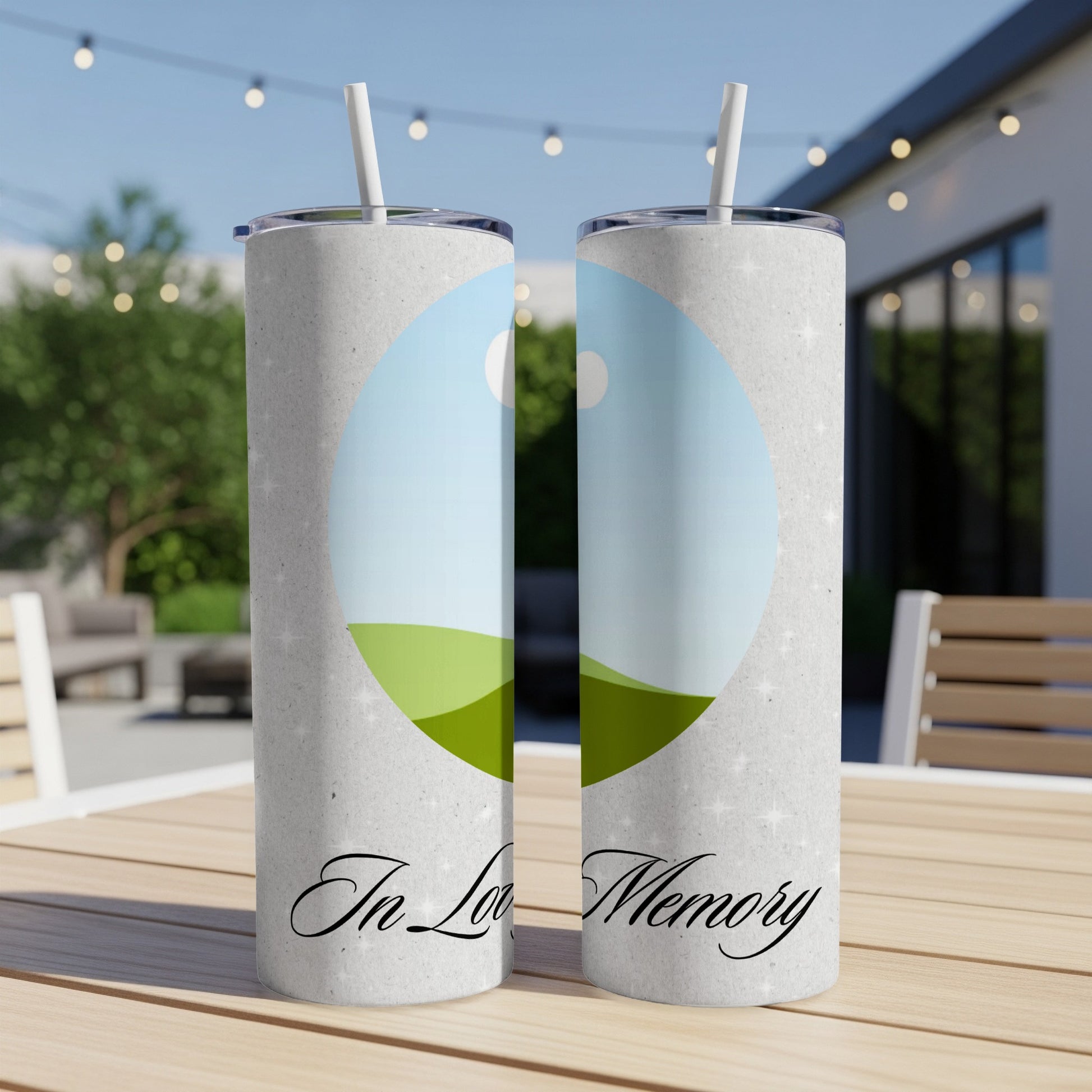Two tumblers with "In Loving Memory" text and a landscape photo on a table.