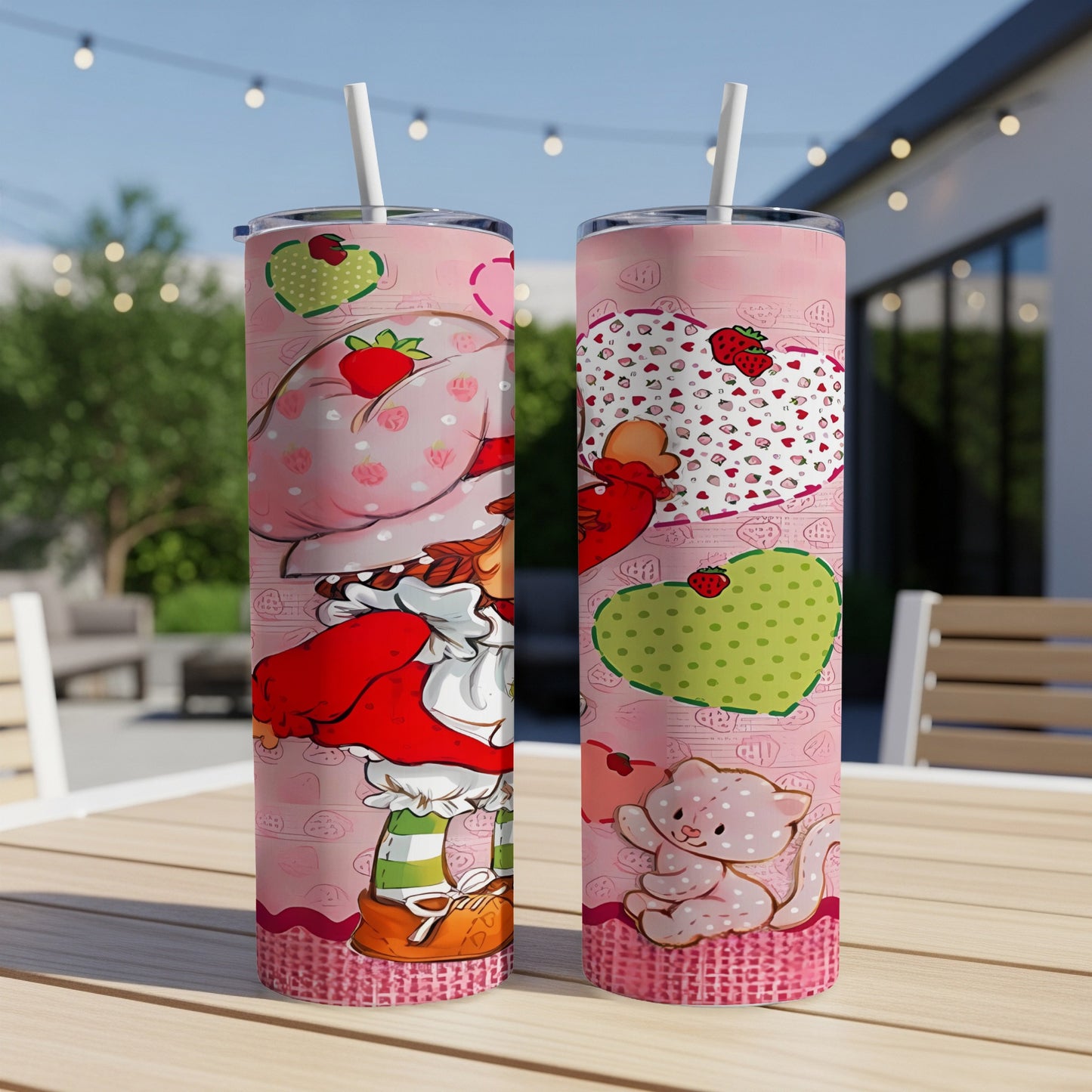 Two Shortcake tumblers with strawberry and pink cat designs, displayed outdoors.