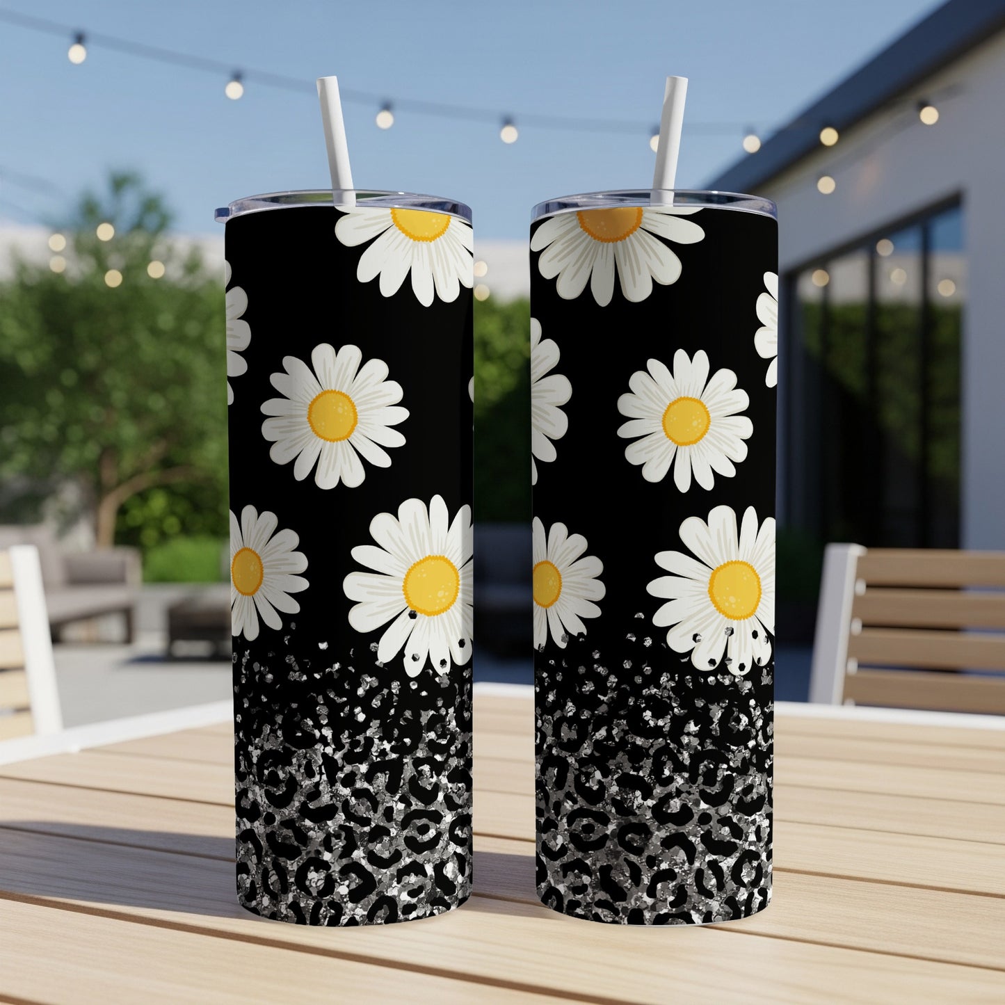 Two black tumblers with white daisies and silver leopard print.
