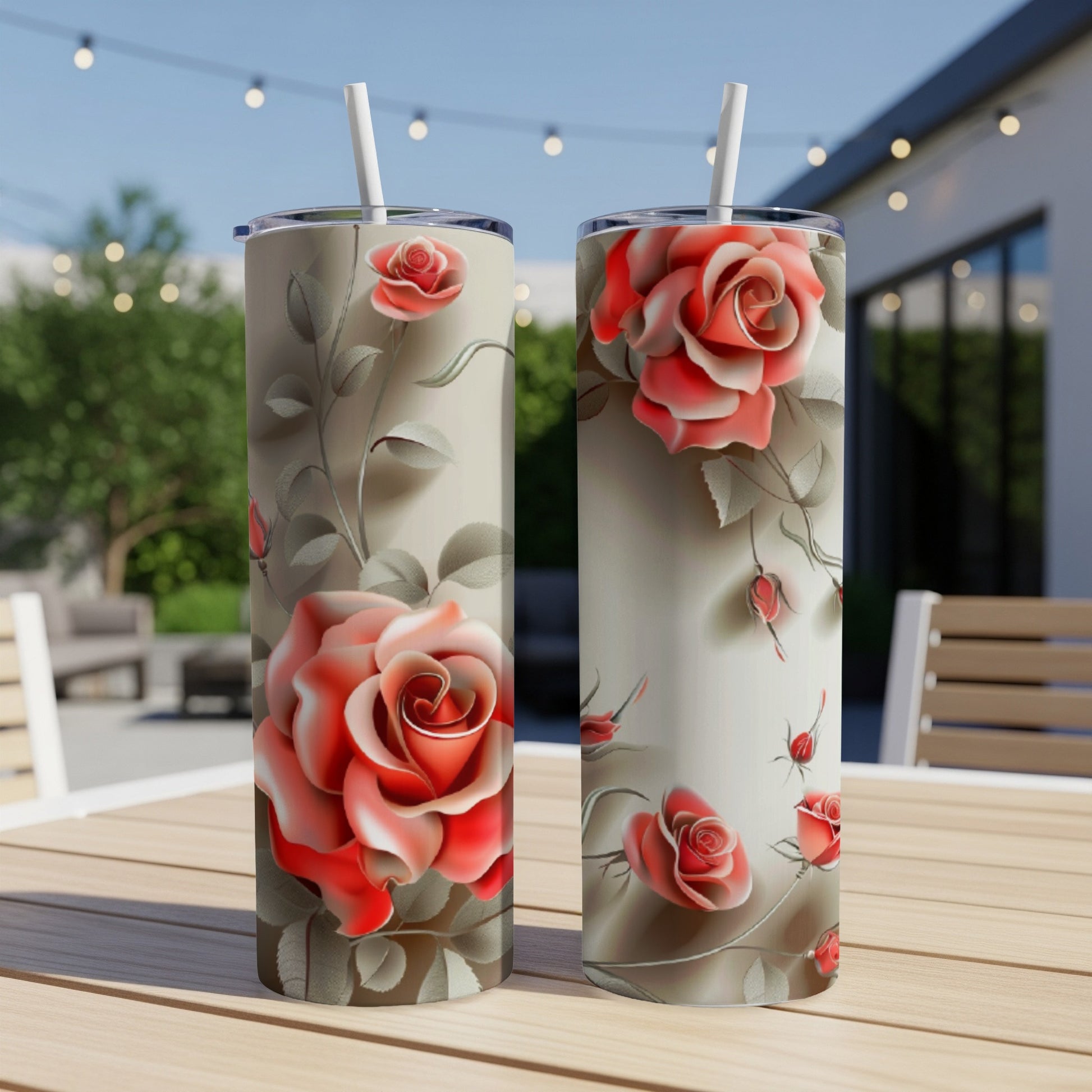 Two tall tumblers featuring a rose floral pattern on a table.