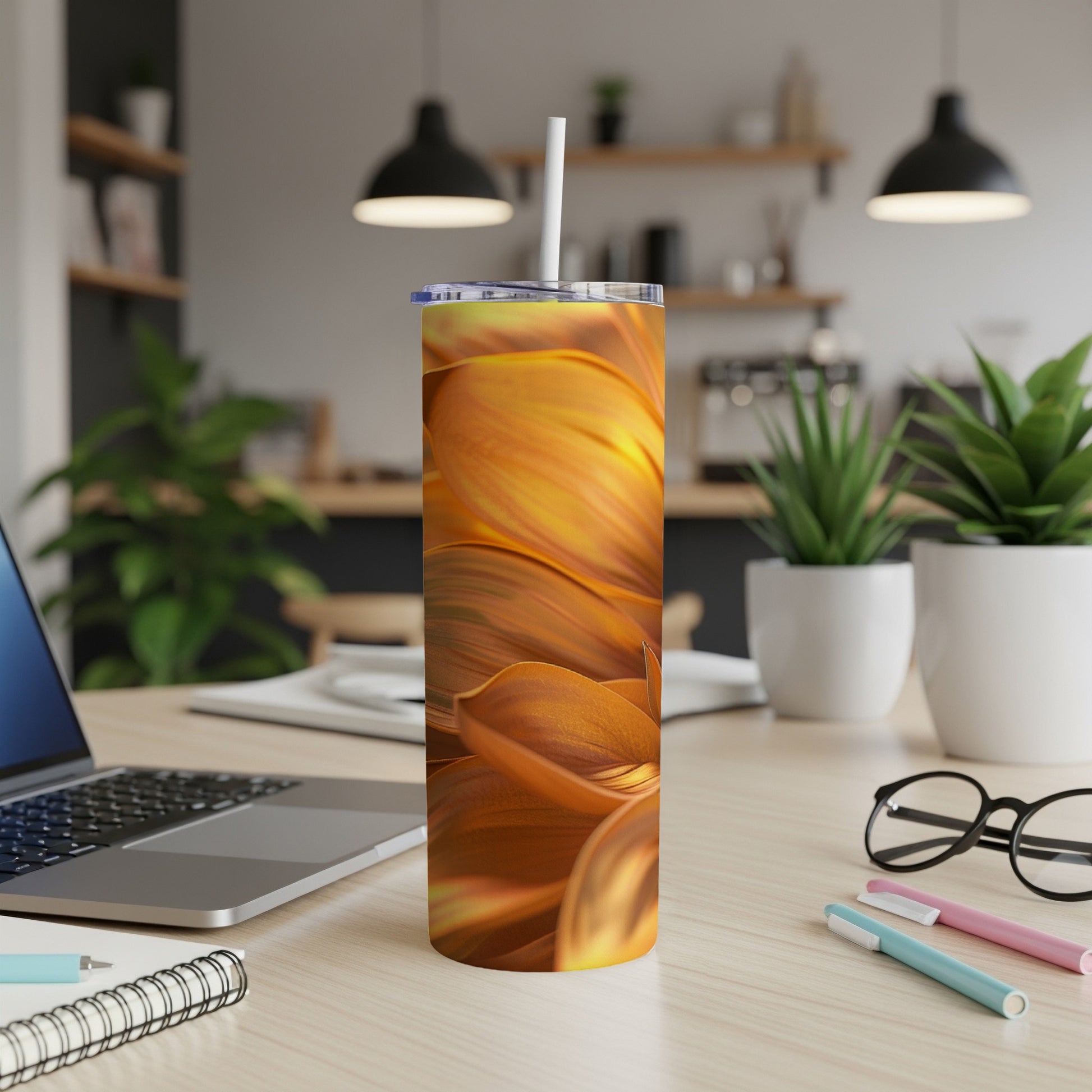 Orange and gold floral pattern skinny tumbler on a desk with a laptop.