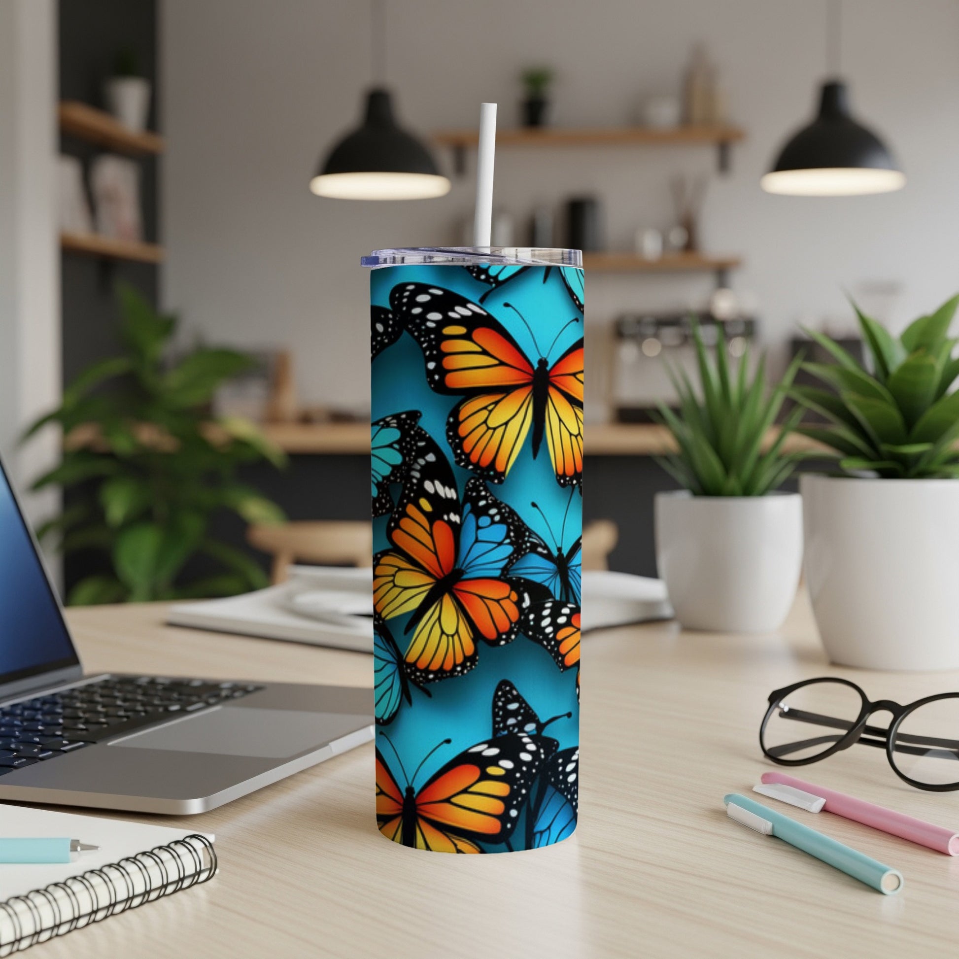 Blue skinny tumbler with a colorful butterfly pattern.