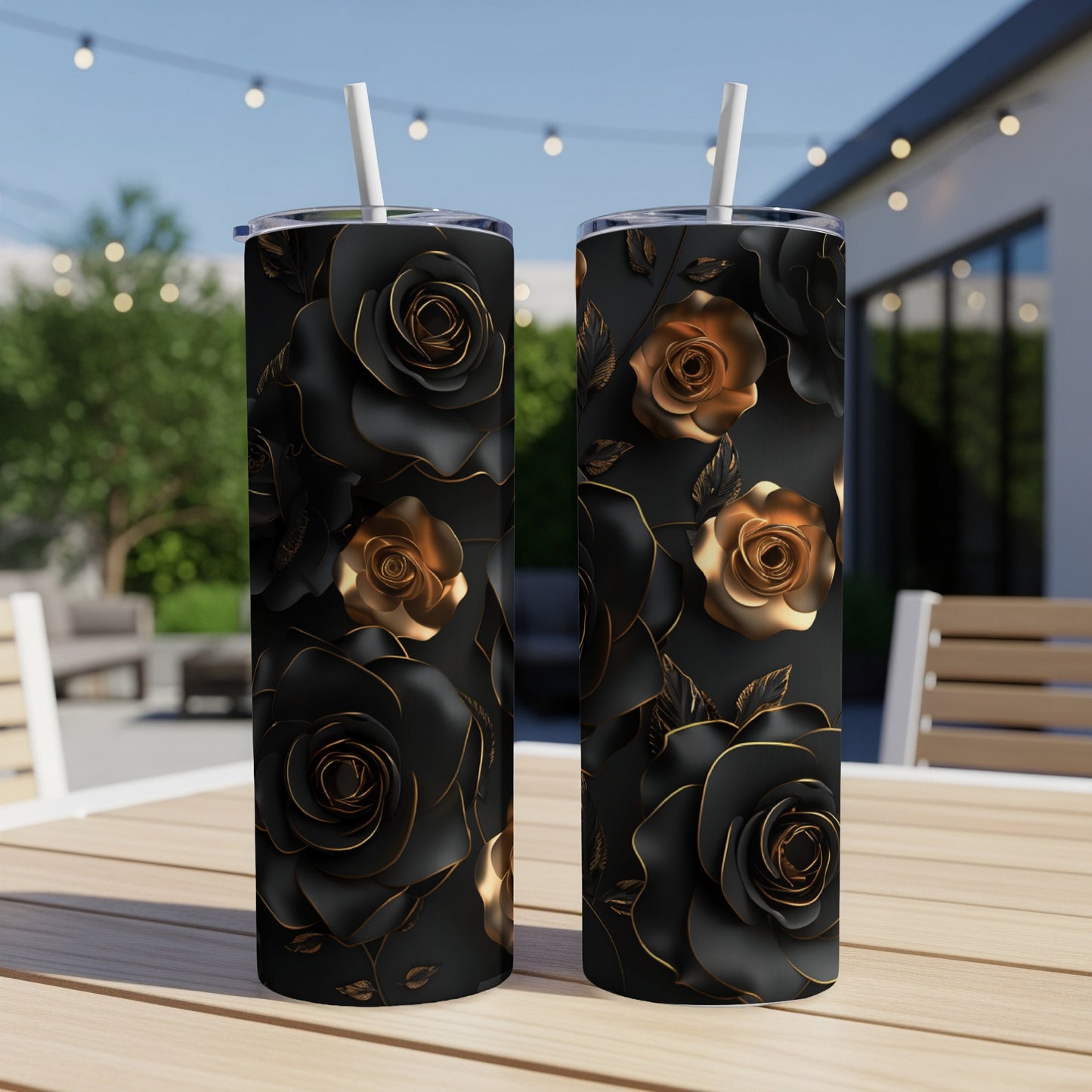 Two black tumblers with raised gold rose and leaf pattern, on a table.