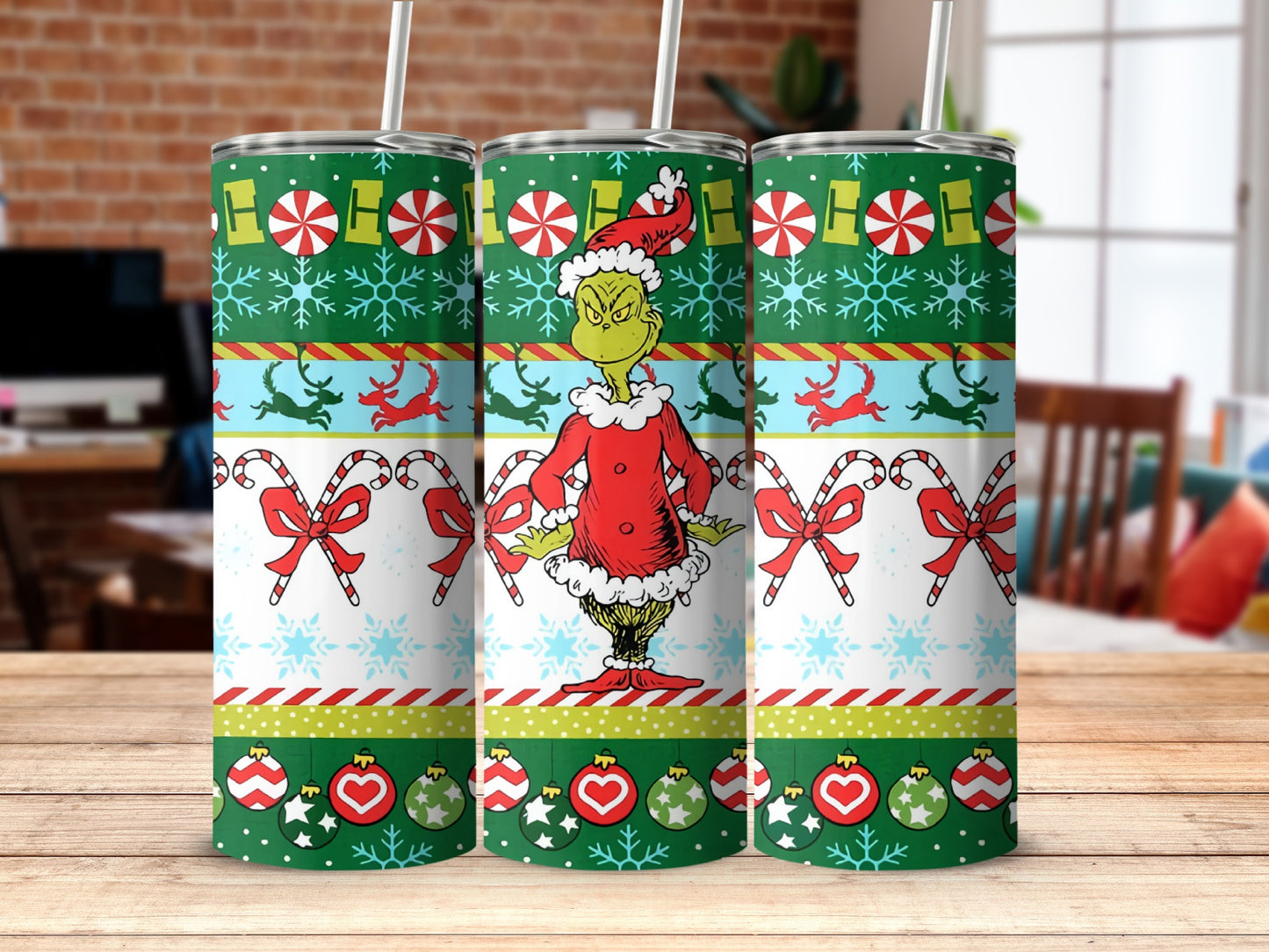 The Grinch on a green, red, and white striped tumbler with candy canes and snowflakes.