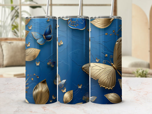 Blue tumbler with gold butterflies and leaves, textured background.