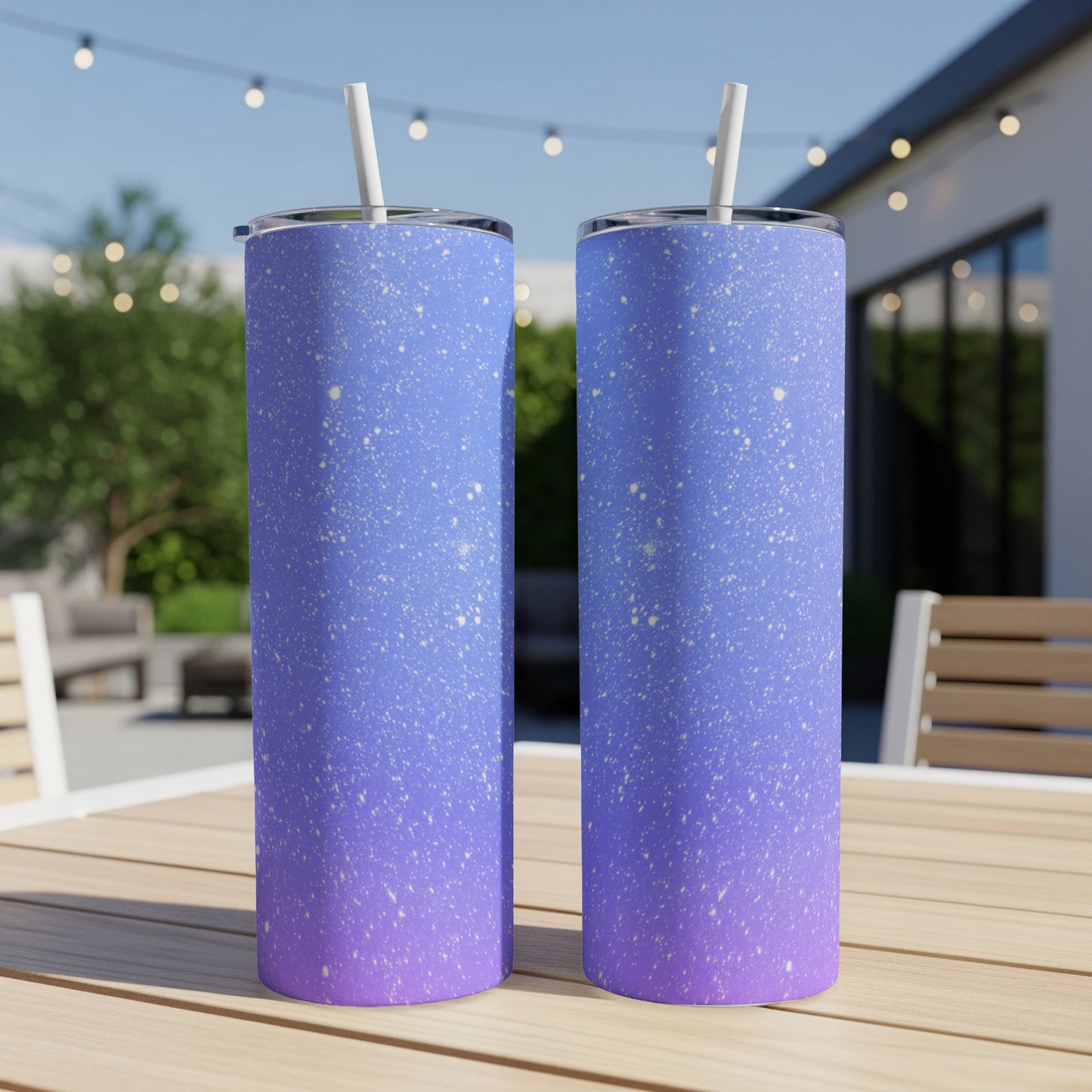 Two tall tumblers with a speckled blue and purple gradient design on a wooden table.
