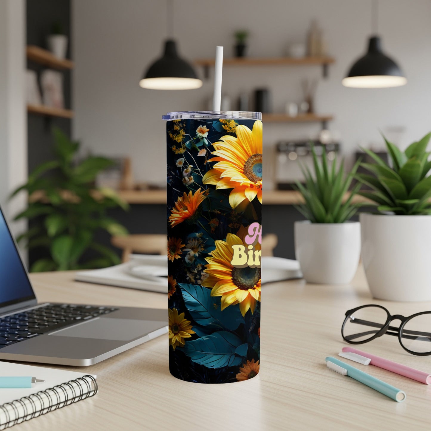 Sunflower and floral print tumbler with "Happy Birthday" text on a desk.