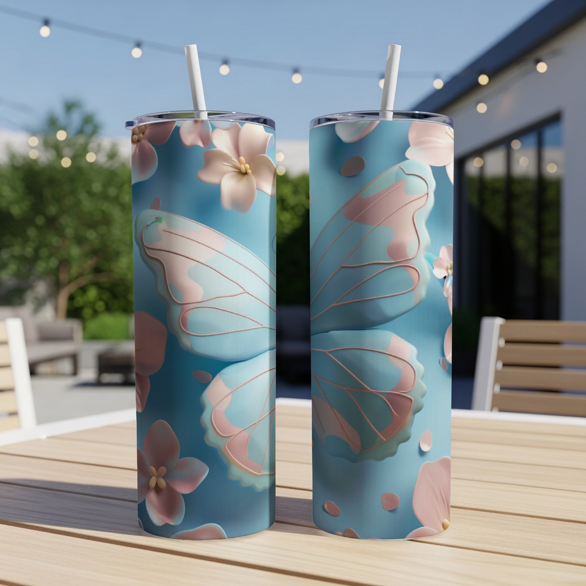Two tall tumblers with a pastel blue butterfly wing and flower design.