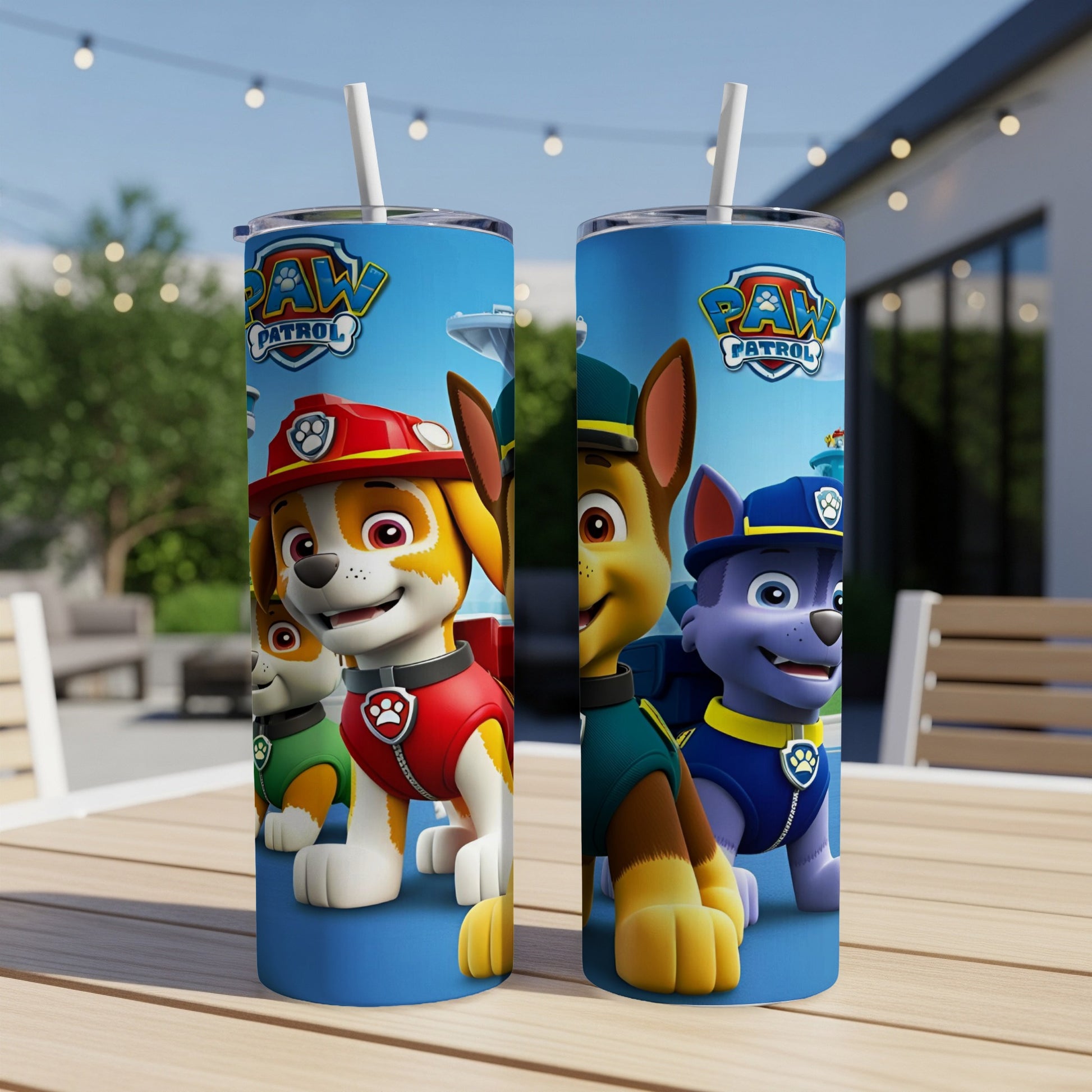 Two Paw Patrol character tumblers with straws on a wooden table.