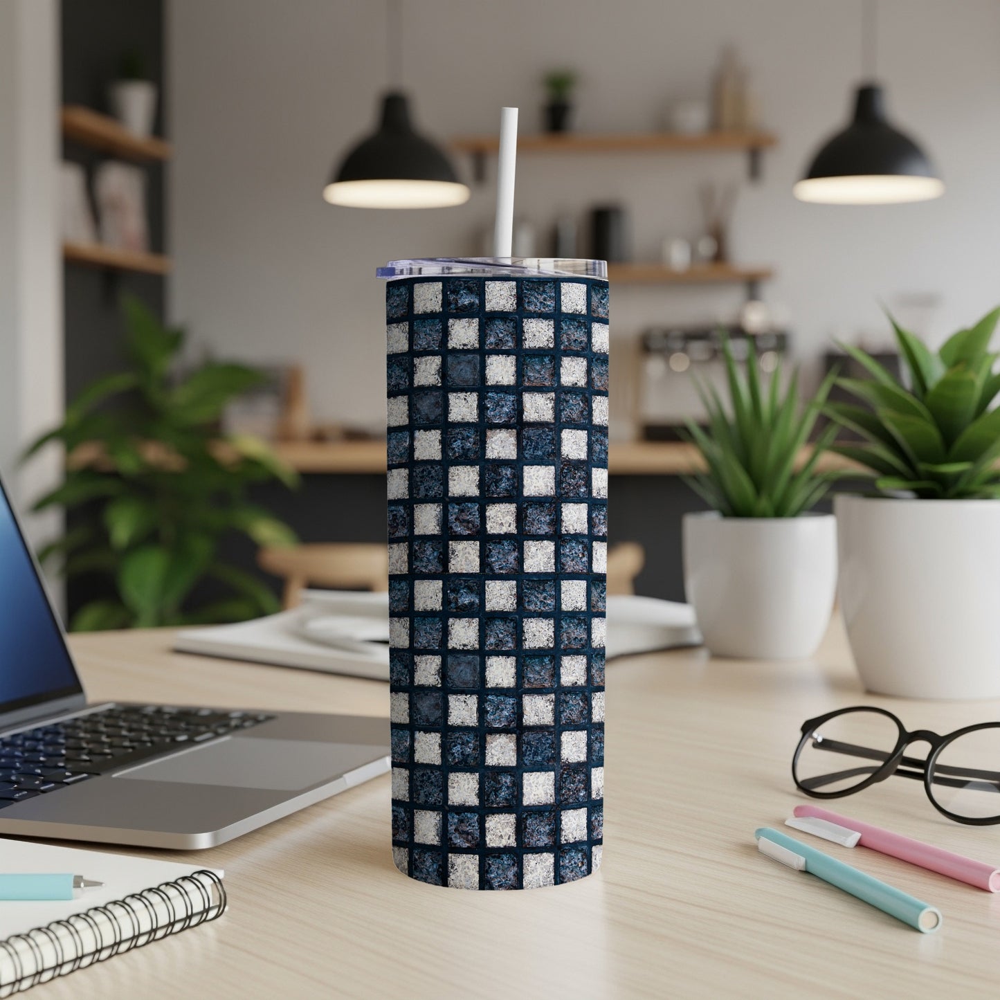 Blue and white tiled pattern on a stainless steel tumbler with straw.