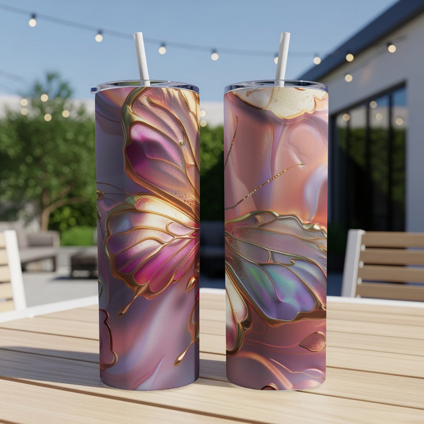 Two tumblers with iridescent butterfly designs sit on a patio table.