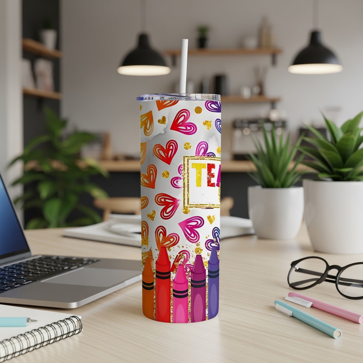 Tumbler with colorful hearts and crayons, text "TEAM" on desk.