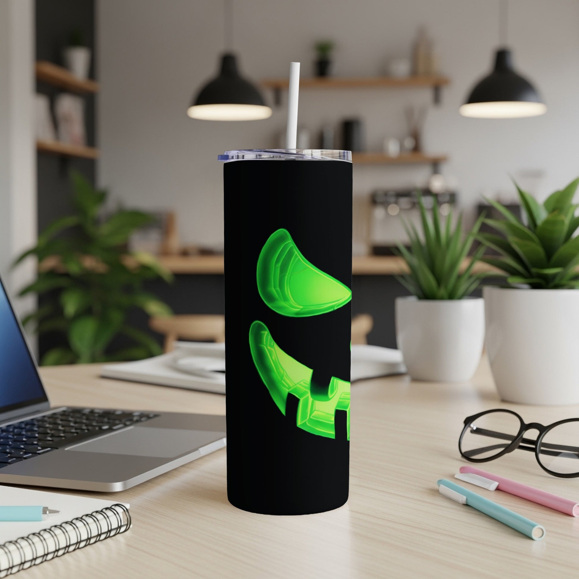 Black tumbler with neon green jack-o'-lantern face and white straw.