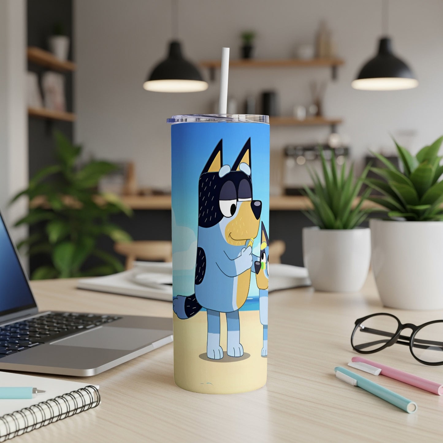 Bluey and Bingo characters on a beach background, on a blue tumbler.