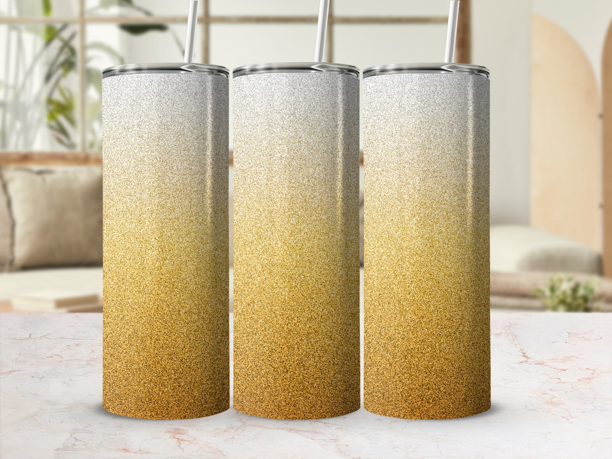 Three glitter gradient tumblers with straws on a marble surface.