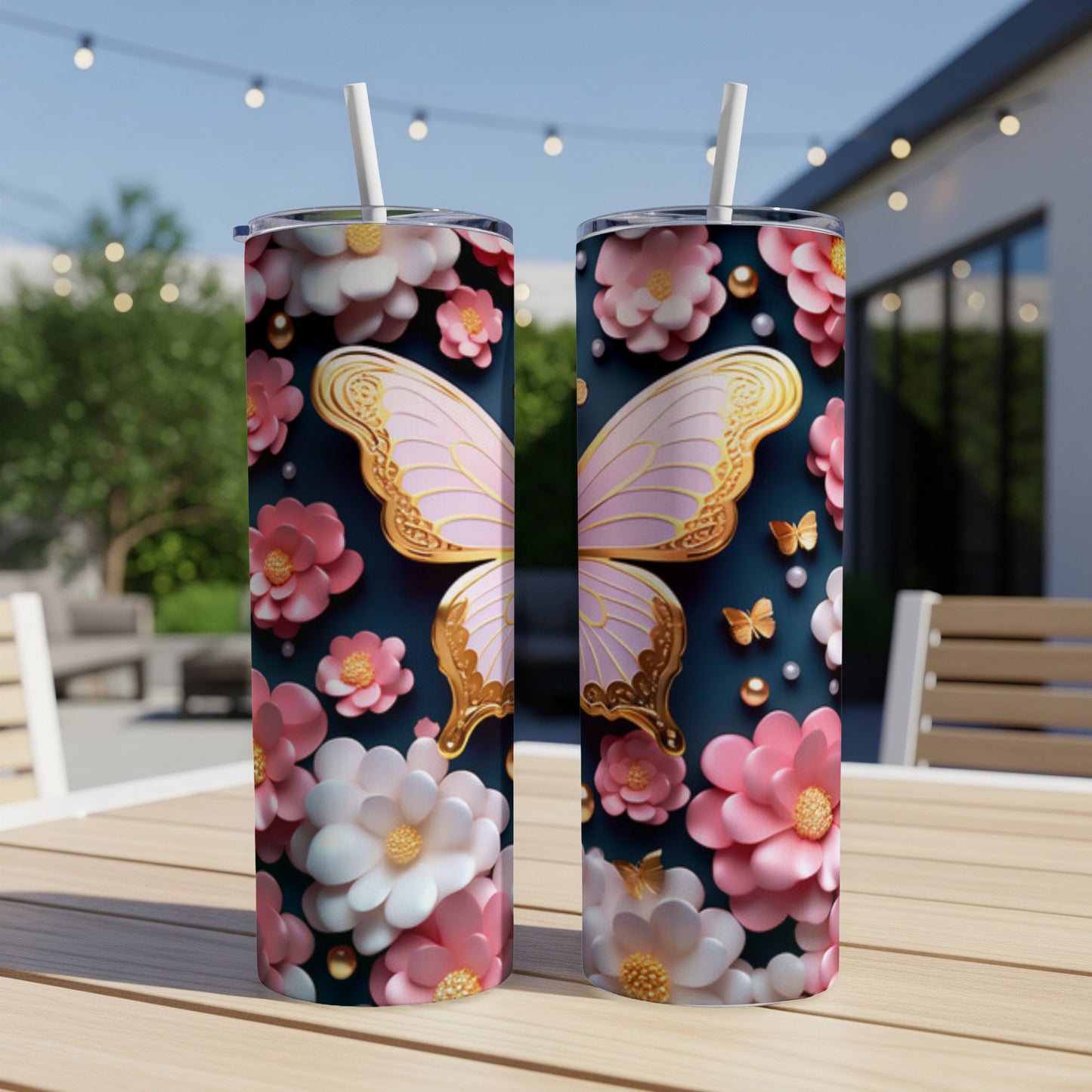 Two tumblers featuring pink butterfly wings and floral designs on a patio table.