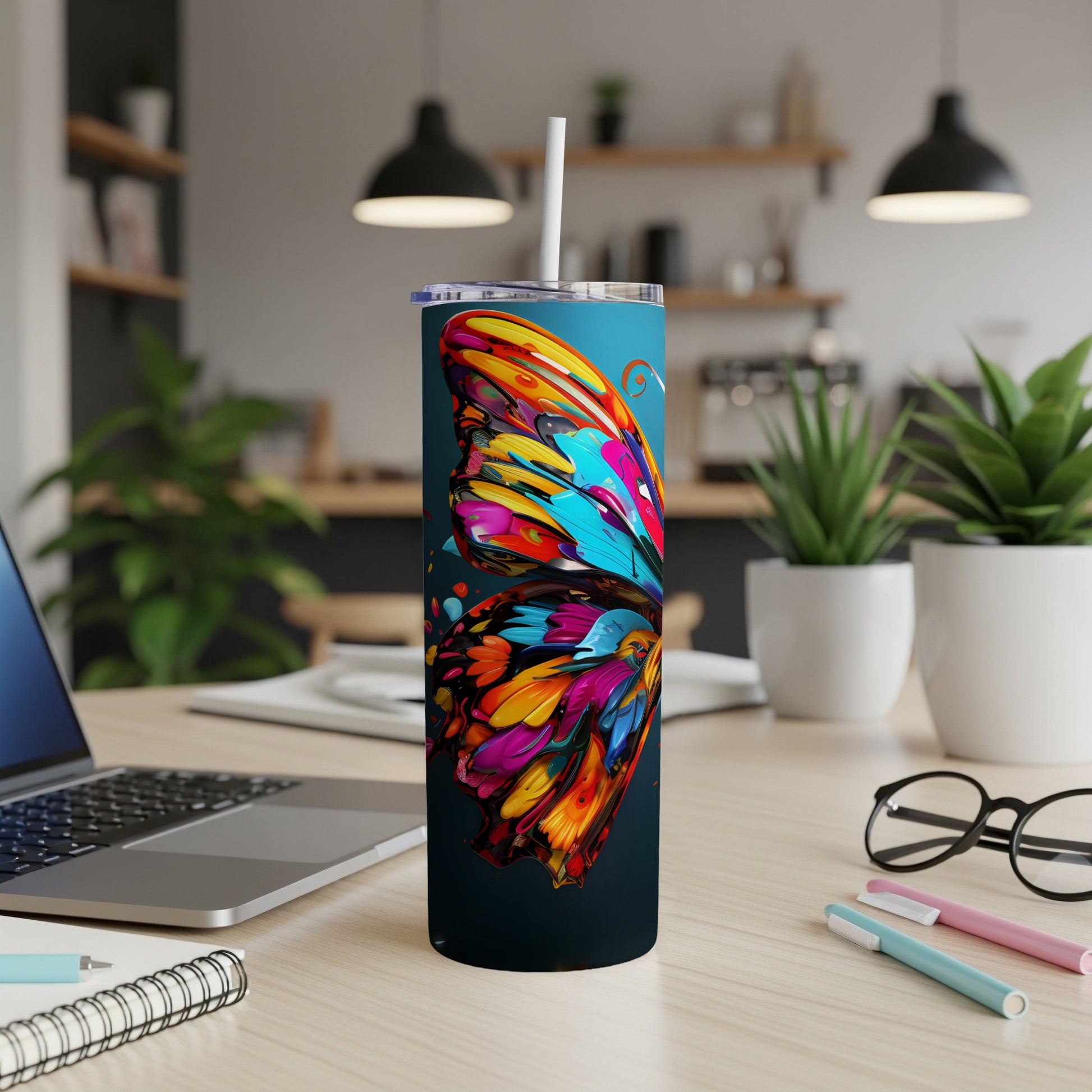 Colorful butterfly design on a dark blue insulated tumbler with a straw.