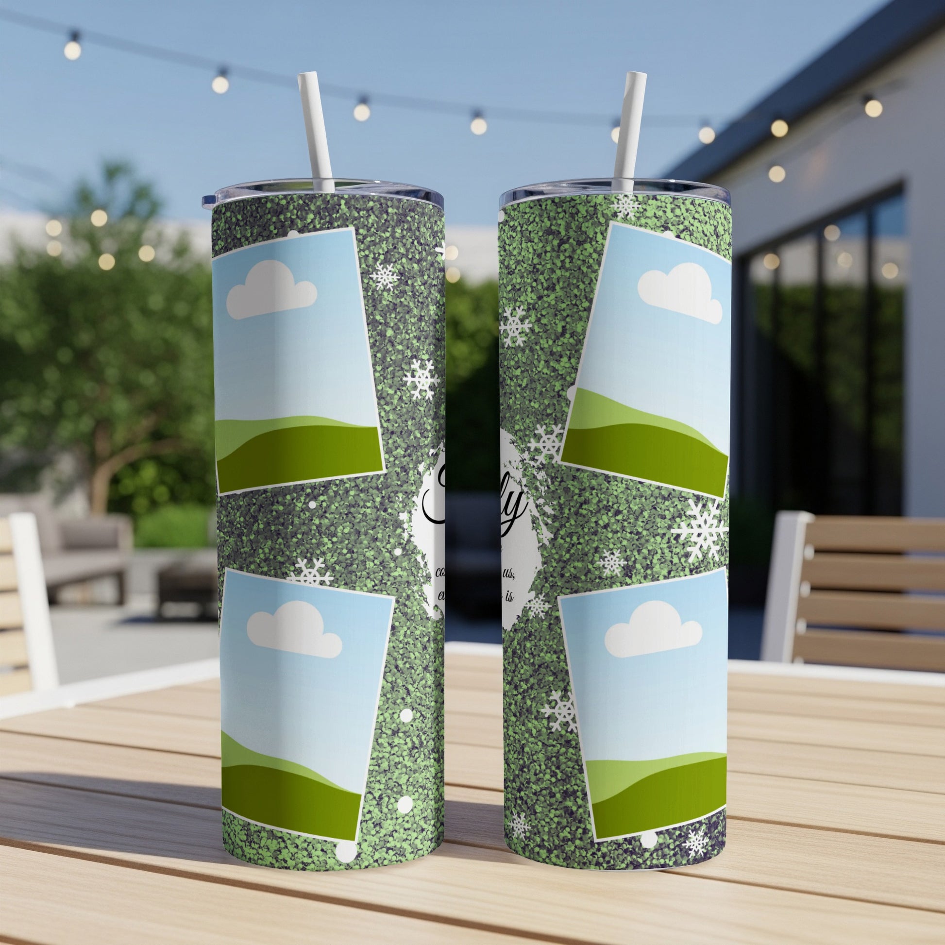 Two tumblers with a green glitter pattern, snowflakes, and photo frames on a table.